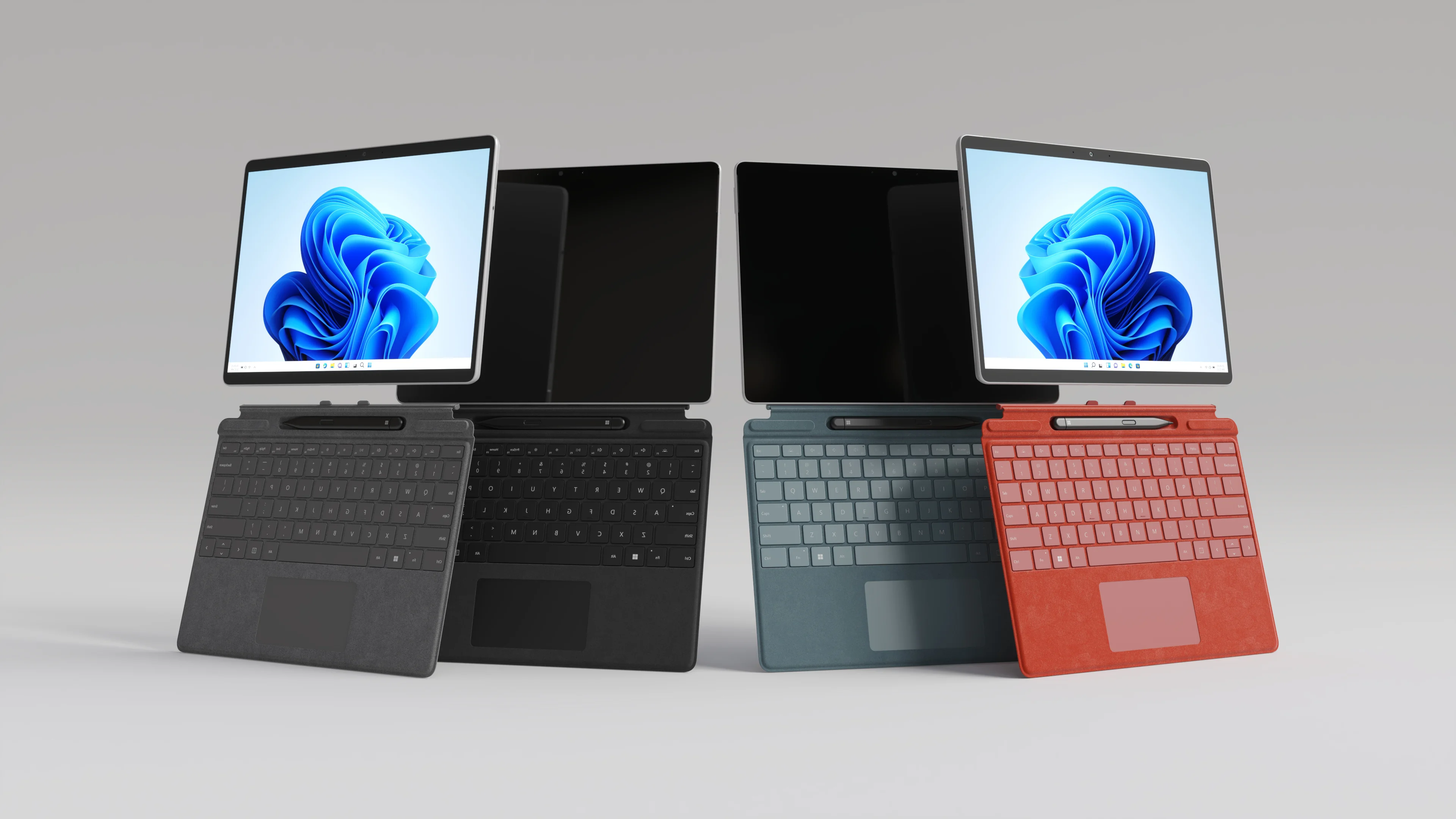 Lineup of tablet devices with detachable keyboards in black, teal, and red rendered in 3D