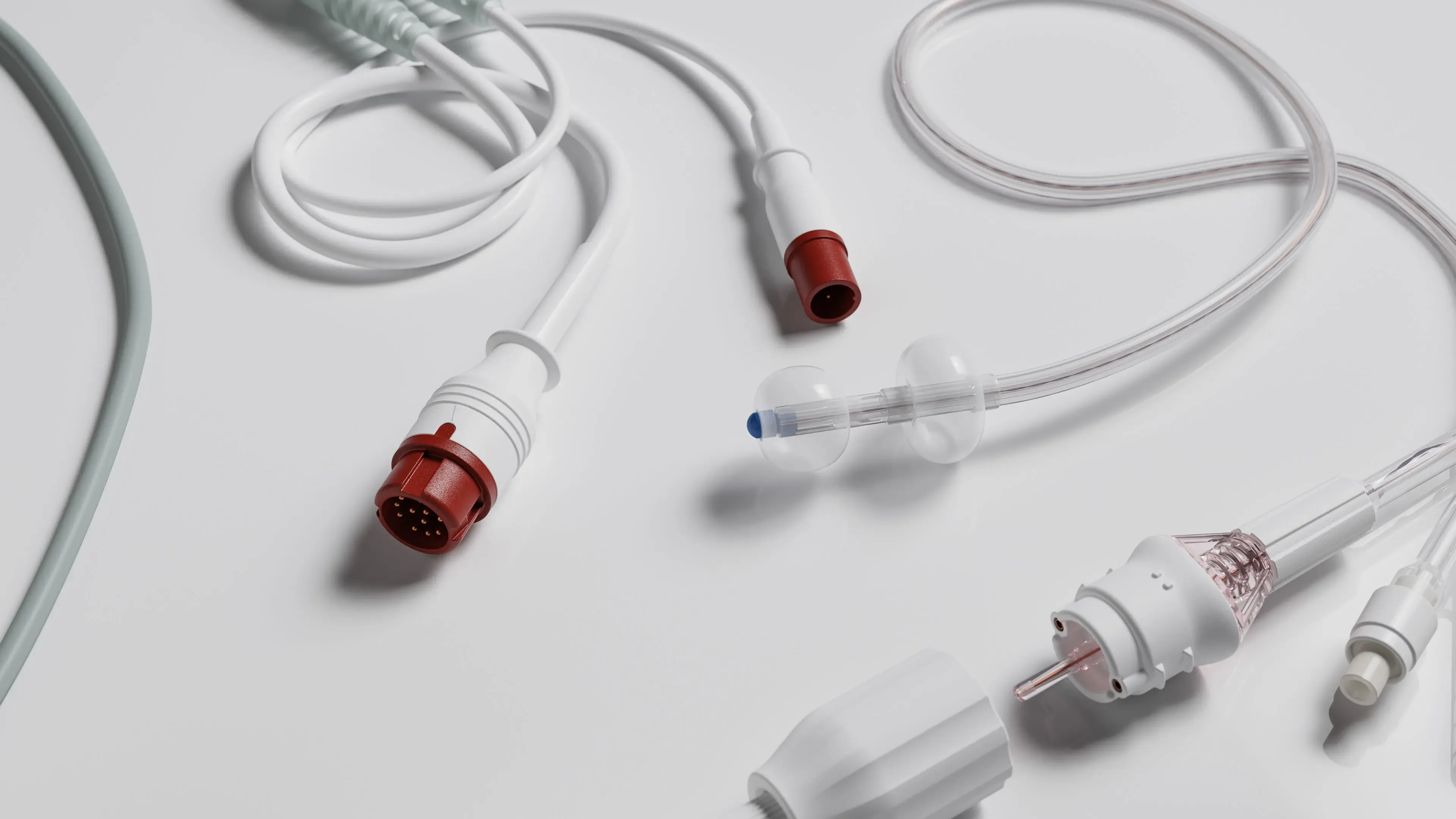 TraumaGuard cables and tubing with red connectors laid out on a white surface